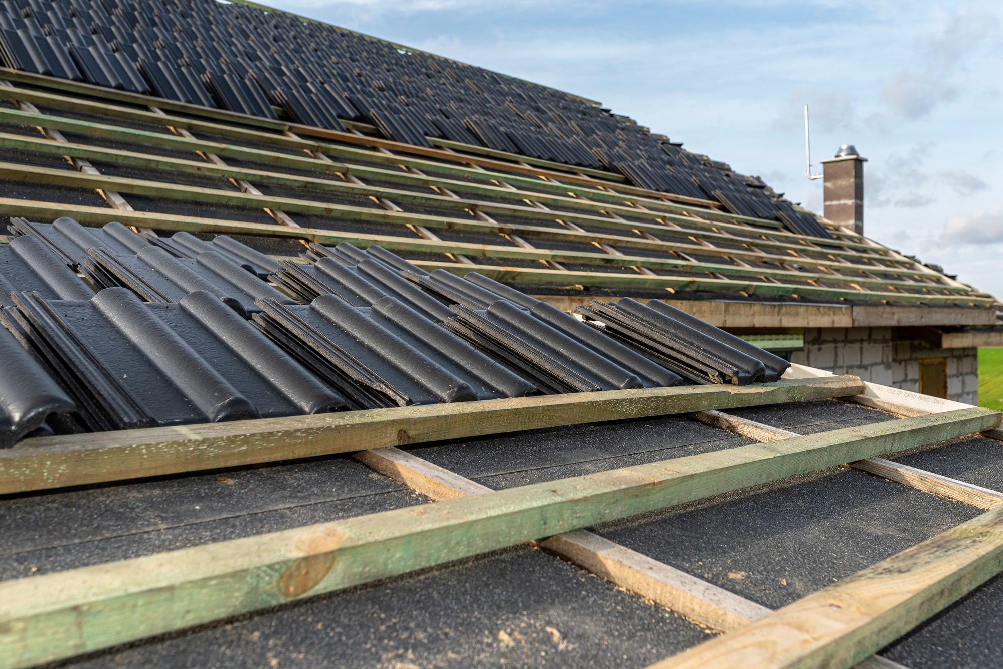 Roof ceramic tile arranged in packets on the roof on roof battens. laying tiles on a boarded roof.